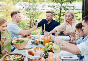 Familia reunida en la mesa brindando y compartiendo un momento de unión y alegría.