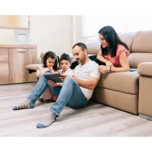 10 Claves Importantes de la guía de crianza saludable para familias 2 Familia reunida en la sala mirando una tablet juntos