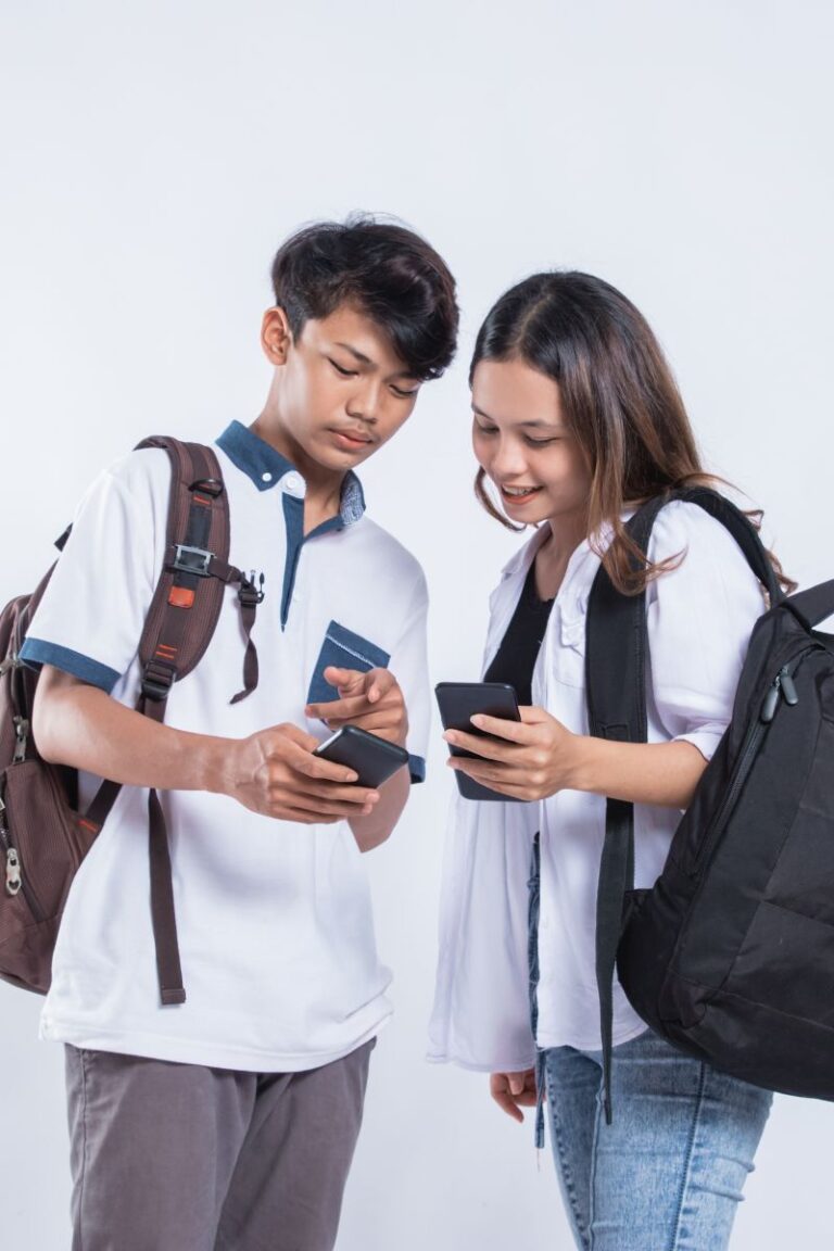 Dos estudiantes adolecentes observando un celular