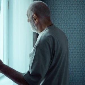 Fortaleza emocional: 3 pasos para convertir el dolor en esperanza 3 Hombre mayor observando por la ventana del cuarto